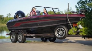 boat on the trailer hooked to truck with people riding up close